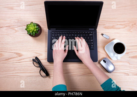 Office desktop setup with female hands working on laptop keyboard Stock Photo