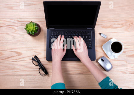 Office desktop setup with female hands working on laptop keyboard Stock Photo