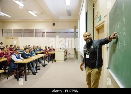 U.S. Military Academy mathematics professor Dr. Samuel Ivy lectures South African students to promote Science, Technology, Engineering and Math (STEM) education as part of the U.S. Africa Command outreach efforts with the African Institute for Mathematical Sciences in Muizenberg, South Africa, June 25, 2018. Ivy was joined by two West Point cadets to help facilitate learning and foster confidence in STEM for the African students. Stock Photo