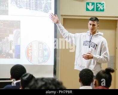 U.S. Military Academy Cadet Matthew Rivera provides an overview of the education programs offered at West Point to South African students in order to promote Science, Technology, Engineering and Math (STEM) education as part of the U.S. Africa Command outreach efforts with the African Institute for Mathematical Sciences in Muizenberg, South Africa, June 25, 2018. Rivera was joined by fellow Cadet Patrick Cowan and Mathematics Professor Dr. Samuel Ivy to help facilitate learning and foster confidence in STEM for the African students. Stock Photo