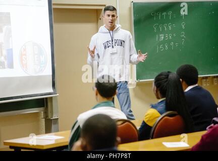 U.S. Military Academy Cadet Matthew Rivera provides an overview of the education programs offered at West Point to South African students in order to promote Science, Technology, Engineering and Math (STEM) education as part of the U.S. Africa Command outreach efforts with the African Institute for Mathematical Sciences in Muizenberg, South Africa, June 25, 2018. Rivera was joined by fellow Cadet Patrick Cowan and Mathematics Professor Dr. Samuel Ivy to help facilitate learning and foster confidence in STEM for the African students. Stock Photo