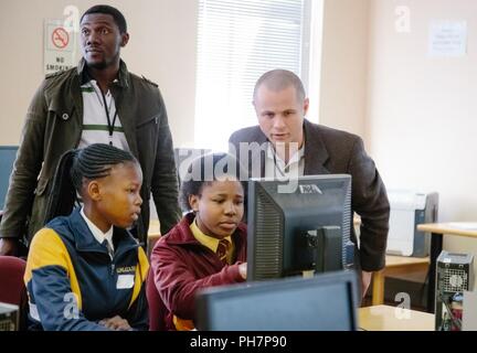 U.S. Navy Lt. Commander Carl Pearson, the AFRICOM Research, Development, Testing and Evaluation liaison assists South African students during practical exercises to promote Science, Technology, Engineering and Math (STEM) education as part of the U.S. Africa Command outreach efforts with the African Institute for Mathematical Sciences in Muizenberg, South Africa, June 25, 2018. Pearson was joined by U.S. Military Academy Cadets Patrick Cowan and Matthew Rivera along with Mathematics Professor Dr. Samuel Ivy to help facilitate learning and foster confidence in STEM for the African students. Stock Photo