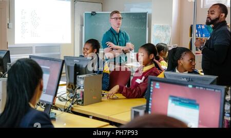 U.S. Military Academy Cadet Patrick Cowan, center, and Mathematics Professor Dr. Samuel Ivy assist South African students during practical exercises to promote Science, Technology, Engineering and Math (STEM) education as part of the U.S. Africa Command outreach efforts with the African Institute for Mathematical Sciences in Muizenberg, South Africa, June 25, 2018. Stock Photo