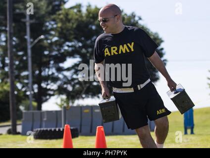 Spc. Ruben Quintana, of the 812th Military Police Company, maneuvers through cones while carrying ammunition cans as he makes his way through a physically challenging obstacle course trying to beat record time during a Fit Camp hosted at Joint Base McGuire-Dix-Lakehurst, New Jersey, June 15, 2018. U.S. Army Reserve Soldiers from the 333rd MP Brigade had the opportunity to attend the Fit Camp, which lasted June 2-16, 2018, hosted by the 336th MP Battalion. The battalion provided the Soldiers with training, coaching and mentorship for the duration of the Fit Camp with the goal of improving their Stock Photo