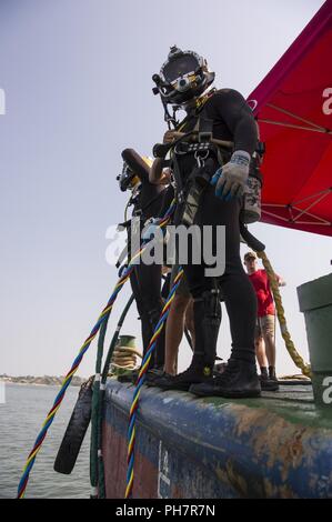 U.S Army divers assigned to 7th Dive Detachment prepare to enter the water during an underwater recovery operation off the coast of Hoang Mai, Vietnam, June 18, 2018. The recovery effort was conducted by the Defense POW/MIA Accounting Agency (DPAA) to locate U.S. service members who went missing during the Vietnam War. DPAA conducts global search, recovery and laboratory operations to provide the fullest possible accounting for our missing personnel to their families and the nation. Stock Photo