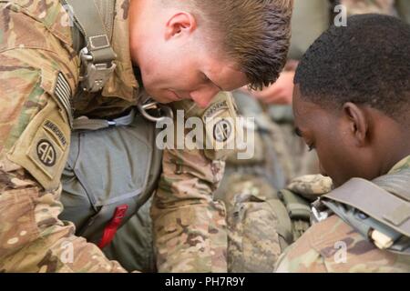 U.S. Army Paratroopers assigned to the 82nd Division prepare to board an Air Force C-130 at Green Ramp in Fort Bragg, North Carolina, June 19, 2018. The train include actions in the aircraft, pre-jump training and parachute landing fall. Stock Photo