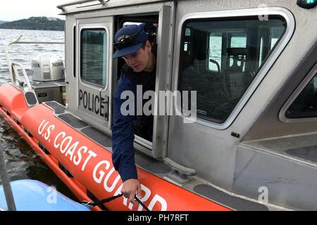 Coast Guard Petty Officer 1st Class Kyle Vaders, a boatswain's mate from the Maritime Safety and Security Team in Seattle pulls his boat up next to a boat crew from Kootenai County Sheriff office on Lake Coeur d'Alene in Idaho, June 30, 2018. Two boat crews worked alongside Kootenai County Sheriff deputies to ensure recreational boating safety during the 4th of July holiday week. Stock Photo