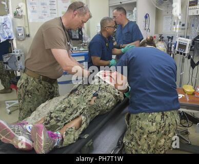 CAMP LEMONNIER, Djibouti – Members of the Expeditionary Medical Facility (EMF) and base emergency services react to mock injuries during an active shooter exercise held at the Navy Exchange on base here, June 26, 2018. Active shooter drills are held quarterly on the installation to prepare service members for real-world situations. Stock Photo