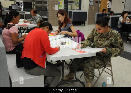 Communities In Schools case manager, Joanne Sanchez, and U.S. Army Reserve Soldier Spc. Launa Bailey, a medical laboratory specialist, complete in-processing with local residents waiting for medical services at Betty Harwell Middle School in Edinburg, Texas. Approximately 50 U.S. Army Reserve Soldiers assigned to the 7235th Medical Support Unit out of Orlando, Texas, worked in partnership with the Texas A&M Colonias program June 16-27 to provide medical care to Hidalgo County’s underserved colonia population.   Services provided by military personnel are done through the Department of Defense’ Stock Photo