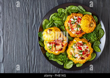 baked Patty Pan squash stuffed with rice, fried chicken meat, crispy fried bacon, bell pepper and served with green fresh spinach leaves and parsley o