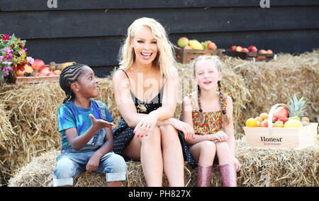 TV personality Katie Piper surprises a group of children, including six year old Alex Buxton-Wilmott(left) and 8 year old Erin Addison(right) with their first ever visit to a farm. The trip comes after it was revealed that a quarter (23%) of UK children have never been to a farm, whilst a fifth (20%) don’t know that apples grow on trees, according to new research by organic juice brand HONEST® Kids. In response, Katie has teamed up with the brand to launch its Pick Your Own Summer campaign, which aims to get kids away from screens and outside fruit picking this summer in a bid to learn how dif Stock Photo