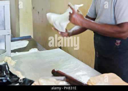 Horizontal portrait of a man making traditional unleavened bread in Sri Lanka. Stock Photo