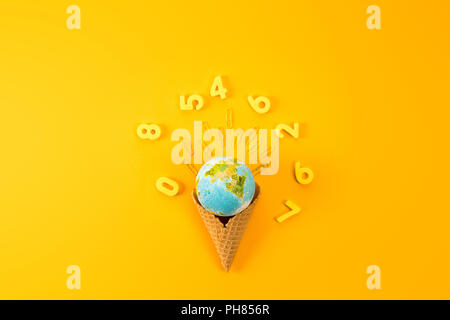 top view of earth globe in waffle cone surrounded with digits on yellow Stock Photo