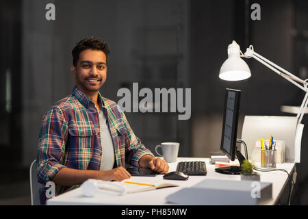 designer with computer working at night office Stock Photo