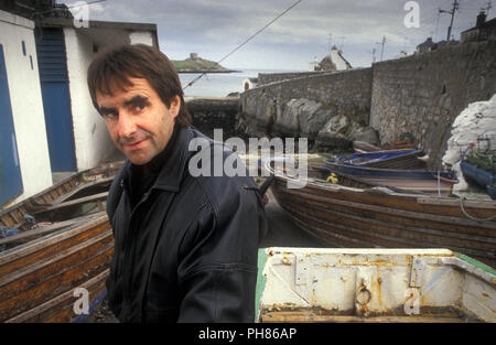 Chris de Burgh singer and songwriter photographed in Coliemore Harbour, Ireland. Dalkey Island in the distance Stock Photo