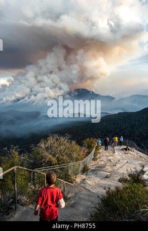 Young boy watching fire hazard reduction at Mount Solitary, Blue Mountains, Australia Stock Photo