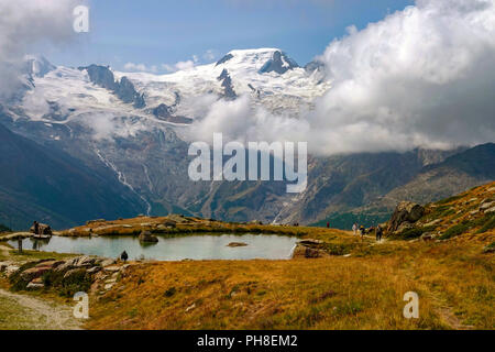 Small lake with waterfall, Summer at Hohe Saas cable-car above Saas Grund, Switzerland, Swiss Alps, Stock Photo