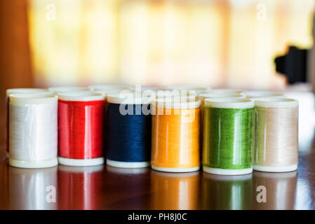 Various colorful yarns or threads on spools or bobbins Stock Photo