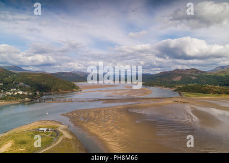 An aerial drone view of the railway viaduct bridge over the Mawddach estuary at Barmouth (Y Bermo / Abermaw in welsh) - a small welsh town and seaside resort , Gwynedd, Snowdonia National Park, North Wales UK (made by a CCA licenced and insured drone operator) Stock Photo