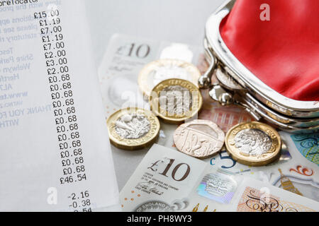 Supermarket shopping till receipt with money Sterling new pound coins and notes and a red cash purse. England, UK, Britain Stock Photo