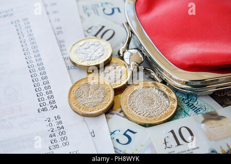 Supermarket shopping till receipts with Sterling money new pound coins banknotes and a red purse. England, UK, Britain Stock Photo