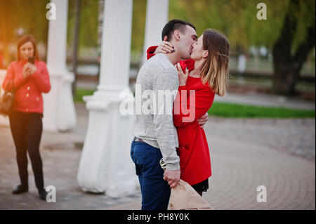 Marriage proposal. Kissed girl and boyfriend with bouquet of flowers Stock Photo