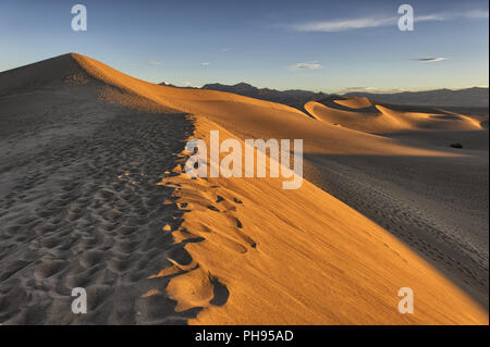 Golden sunrise and footsteps on Mesquite Flat Sand Dunes