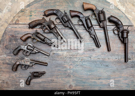 High resolution image of historical guns and pistols on a vintage wood background in an exhibit in a museum or collectors showcase Stock Photo