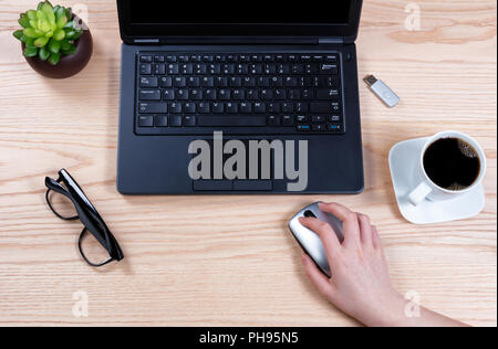 Office desktop setup with female hand holding wireless computer mouse Stock Photo