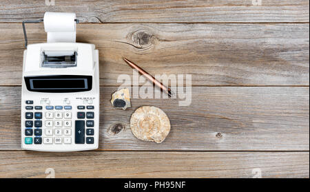 Vintage adding machine and stone fossils on rustic wooden boards Stock Photo