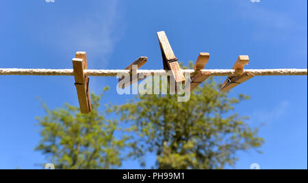 Empty clothesline with wooden clamps Stock Photo