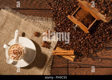 Coffee cup, star anise, cinnamon sticks and coffee-beans Stock Photo