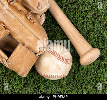 Close up overhead view of old baseball equipment on grass Stock Photo