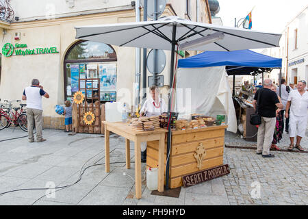 Elderly Lady selling traditional smoked cheese from Podhale region Oscypek and Golka made from salted sheep milk. Market Stall in Krosno, Poland Stock Photo