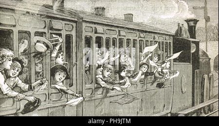Victorian children on a steam train, waving flags, hankies and hats Stock Photo