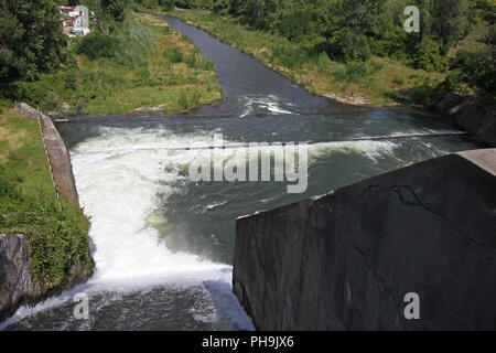 Dam wall and overflow of Iskar Dam. Water flowing over a dam wall. Mist rising above the Iskar dam wall. Cascade from a hydroelectric plant. Lake wate Stock Photo