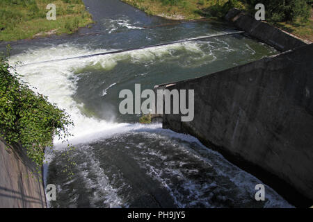 Dam wall and overflow of Iskar Dam. Water flowing over a dam wall. Mist rising above the Iskar dam wall. Cascade from a hydroelectric plant. Lake wate Stock Photo