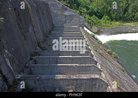 Dam wall and overflow of Iskar Dam. Water flowing over a dam wall. Mist rising above the Iskar dam wall. Cascade from a hydroelectric plant. Lake wate Stock Photo