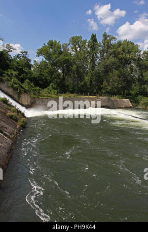 Dam wall and overflow of Iskar Dam. Water flowing over a dam wall. Mist rising above the Iskar dam wall. Cascade from a hydroelectric plant. Lake wate Stock Photo