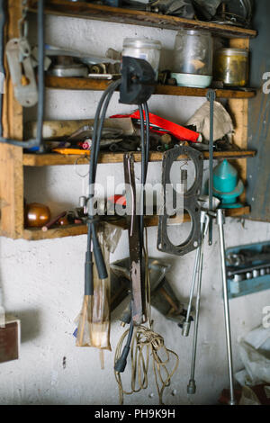 Messy shelf in the garage with old tools, cables and car parts Stock Photo