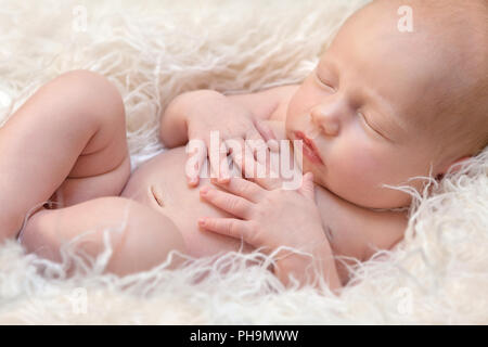 Newborn baby girl sleeping on a fluff Stock Photo