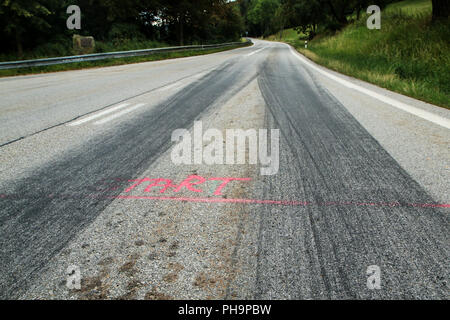 The rubber tracks from the racing cars left on the tarmac at the start of the hill climb stage. Stock Photo