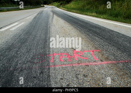 The rubber tracks from the racing cars left on the tarmac at the start of the hill climb stage. Stock Photo