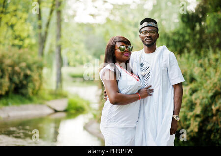 Rich african couple at white national dress and sunglasses Stock Photo