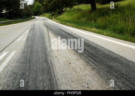 The rubber tracks from the racing cars left on the tarmac at the start of the hill climb stage. Stock Photo