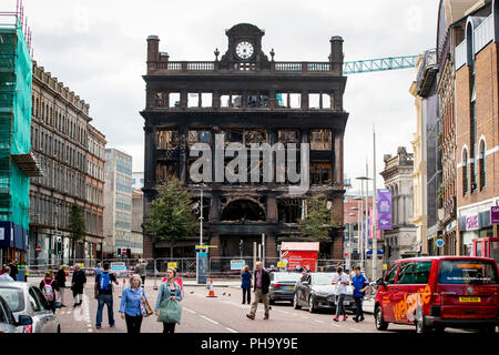 People stop to look at the historic five-storey Bank Buildings in Belfast city centre, where a major blaze broke out in the Primark store on Tuesday. Stock Photo