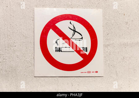 A close up view of a no smoking sign on a white wall Stock Photo