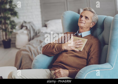 Delighted gray-haired man having rest at home Stock Photo