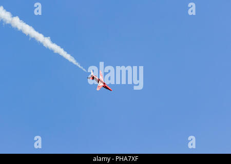 RAF Red Arrows plane with white smoke trail flying over Bournemouth during a display at the Bournemouth Air Festival, Thursday 30 August 2018 Stock Photo