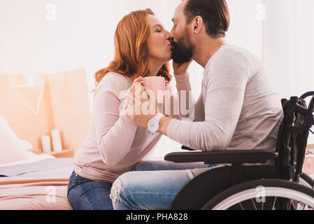 Mid aged loving couple kissing at home Stock Photo